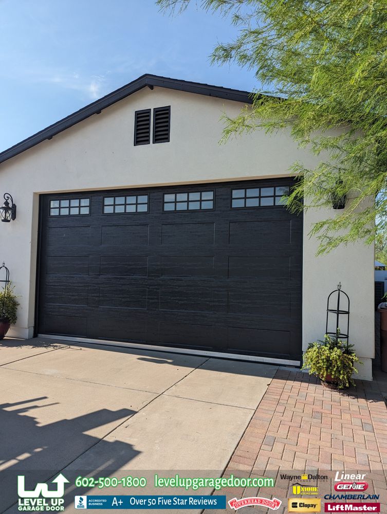Modern black garage door installed on a desert contemporary home